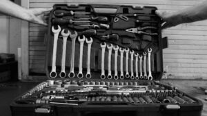 Black and white image of a complete toolset in an open box, perfect for garages and repairs.