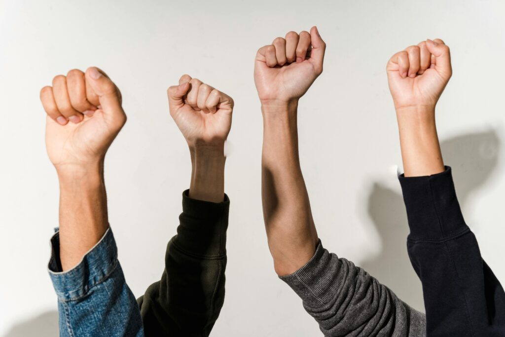 Close-up of diverse raised fists symbolizing unity, strength, and victory.
